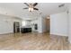 Open-concept living area showcasing wood-look tile floors, a modern kitchen with stainless appliances, and a ceiling fan at 2430 Sanderling St, Haines City, FL 33844