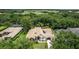 Aerial view of a luxury estate surrounded by lush greenery and a golf course in the background at 25813 Feather Ridge Ln, Sorrento, FL 32776