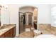 Bright bathroom showcasing dual sinks, a glass shower, and a soaking tub with neutral tiling at 25813 Feather Ridge Ln, Sorrento, FL 32776
