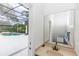 A bathroom with a long vanity and an entrance leading out to the screened-in pool at 25813 Feather Ridge Ln, Sorrento, FL 32776