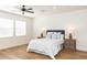Comfortable bedroom featuring light hardwood flooring and a ceiling fan and two side tables at 25813 Feather Ridge Ln, Sorrento, FL 32776
