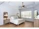 Bright bedroom featuring a ceiling fan and two windows that provide natural light and wood flooring at 25813 Feather Ridge Ln, Sorrento, FL 32776