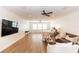 Spacious bonus room featuring a large TV, modern furniture, and wood flooring and three large windows at 25813 Feather Ridge Ln, Sorrento, FL 32776