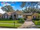 Charming single-story home featuring stone accents, mature landscaping, and a porte-cochere at 25813 Feather Ridge Ln, Sorrento, FL 32776