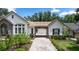Beautiful home with a stone porte cochere, lush landscaping, and a manicured lawn at 25813 Feather Ridge Ln, Sorrento, FL 32776
