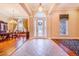 Inviting foyer with high ceilings, decorative columns, tiled floors, chandelier, and transom window over the front door at 25813 Feather Ridge Ln, Sorrento, FL 32776