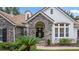 Inviting front entrance with stone accents, a decorative door, and well-maintained landscaping at 25813 Feather Ridge Ln, Sorrento, FL 32776