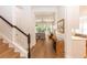 Hallway featuring hardwood floors leading to a spacious living area with views of the backyard at 25813 Feather Ridge Ln, Sorrento, FL 32776