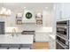 Bright kitchen featuring custom cabinetry, quartz countertops, a stainless range and modern appliances at 25813 Feather Ridge Ln, Sorrento, FL 32776
