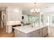 Large kitchen island featuring white countertop, ample storage, and a view of the cozy living room at 25813 Feather Ridge Ln, Sorrento, FL 32776