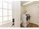 Bright laundry room with modern washer and dryer, complemented by neutral walls and hardwood flooring at 25813 Feather Ridge Ln, Sorrento, FL 32776