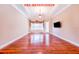 Spacious living room boasts hardwood floors, a tray ceiling, and large window, before renovation at 25813 Feather Ridge Ln, Sorrento, FL 32776