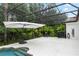 Screened patio with lush landscaping offers a private oasis for relaxation and outdoor enjoyment at 25813 Feather Ridge Ln, Sorrento, FL 32776