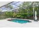 Screened-in pool with a connected spa and neutral-colored concrete pool deck surrounded by lush landscaping at 25813 Feather Ridge Ln, Sorrento, FL 32776