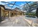 Relaxing screened-in pool with a tanning ledge and patio with tiled flooring and white columns at 25813 Feather Ridge Ln, Sorrento, FL 32776