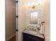 Chic powder room with a decorative mirror, stylish vanity, and attractive lighting fixtures at 25813 Feather Ridge Ln, Sorrento, FL 32776