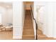 Staircase with hardwood steps and white risers and railing, and a dark wood handrail at 25813 Feather Ridge Ln, Sorrento, FL 32776