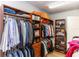 The large walk-in closet has wooden shelving, providing ample storage space at 25813 Feather Ridge Ln, Sorrento, FL 32776