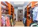 This expansive walk-in closet has wooden shelving and rods, giving lots of room for clothing at 25813 Feather Ridge Ln, Sorrento, FL 32776