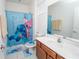 Bathroom featuring a vanity with a white sink, light blue shower curtain, and tile flooring at 2659 Calistoga Ave, Kissimmee, FL 34741