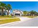 Beautiful two-story home with a two-car garage, green lawn, and elegant palm tree landscaping at 2659 Calistoga Ave, Kissimmee, FL 34741