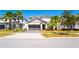 Charming two-story home featuring a well-manicured lawn, a two-car garage, and beautiful palm trees at 2659 Calistoga Ave, Kissimmee, FL 34741