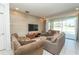 Cozy living room with comfortable seating, a mounted TV, and sliding glass doors to the outdoor patio at 2659 Calistoga Ave, Kissimmee, FL 34741