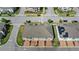 An aerial view shows a neighborhood with well-manicured lawns, crosswalks, and townhomes with brick-paved driveways at 2694 Giardino Loop, Kissimmee, FL 34741