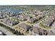 An aerial view showcases a vibrant residential community with a lake, townhomes, and single-Gathering homes at 2694 Giardino Loop, Kissimmee, FL 34741