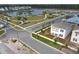 A picturesque community aerial view showcases a two-story home, lush landscaping, and a peaceful pond at 3002 Voyager Ave, St Cloud, FL 34771