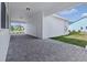 Open carport with brick pavers providing shelter and access to the home's side entrance at 3002 Voyager Ave, St Cloud, FL 34771