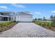 Long brick driveway leading to a two-car garage, enhanced by meticulous landscaping and exterior lighting at 3002 Voyager Ave, St Cloud, FL 34771