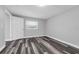 Empty bedroom with hard wood floors, fresh paint, a large window, and a door leading outside at 3151 S Bumby Ave, Orlando, FL 32806