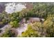 Stunning aerial view of home nestled amongst lush green trees with a pool and lake nearby at 38851 Forest Dr, Eustis, FL 32736