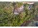 Home with a pool and small red barn surrounded by a lush green forest, aerial view at 38851 Forest Dr, Eustis, FL 32736