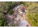 Aerial view of a home with a pool, detached garage, and surrounded by lush trees at 38851 Forest Dr, Eustis, FL 32736