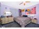 Cozy bedroom with a comfortable bed, dresser, decorative flags, and carpeted floor at 38851 Forest Dr, Eustis, FL 32736