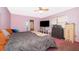 Comfortable bedroom with a large bed, dresser, television, and a sliding door to an outdoor space at 38851 Forest Dr, Eustis, FL 32736