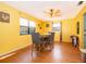 Cozy dining area with wood floors, a wooden table and chairs, and lots of natural light from two large windows at 38851 Forest Dr, Eustis, FL 32736