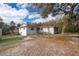 Home with a large sand yard, partially fenced with a wooden deck and steps on the side at 38851 Forest Dr, Eustis, FL 32736