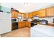 Galley kitchen features wood cabinets, tile floor, and modern appliances at 38851 Forest Dr, Eustis, FL 32736