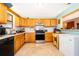 Galley kitchen with wood cabinets, a tile backsplash, and updated appliances at 38851 Forest Dr, Eustis, FL 32736
