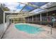 Clear blue pool with screen enclosure, concrete deck, and view of the house at 38851 Forest Dr, Eustis, FL 32736