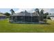 Backyard view of a screened pool and lush green lawn at 39 Fellowship Dr, Palm Coast, FL 32137