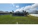 Backyard view of a screened pool and lush green lawn at 39 Fellowship Dr, Palm Coast, FL 32137