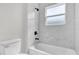 Bathroom featuring tiled walls, tub, modern fixtures, and a window for natural light at 3984 Sw 151St St, Ocala, FL 34473