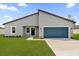 Charming single-story home with a blue garage door, gray facade, and well-manicured lawn at 3984 Sw 151St St, Ocala, FL 34473