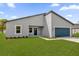 Contemporary one-story home featuring blue garage door, sleek facade, and green lawn at 3984 Sw 151St St, Ocala, FL 34473