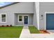 Close up of the front entrance of a modern home with a blue front door and manicured lawn at 3984 Sw 151St St, Ocala, FL 34473