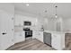 Modern kitchen with white cabinetry, stainless steel appliances, and a view to the living area at 3984 Sw 151St St, Ocala, FL 34473